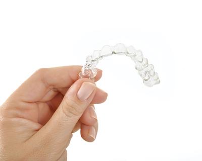 patient holding invisalign aligner in huntsville